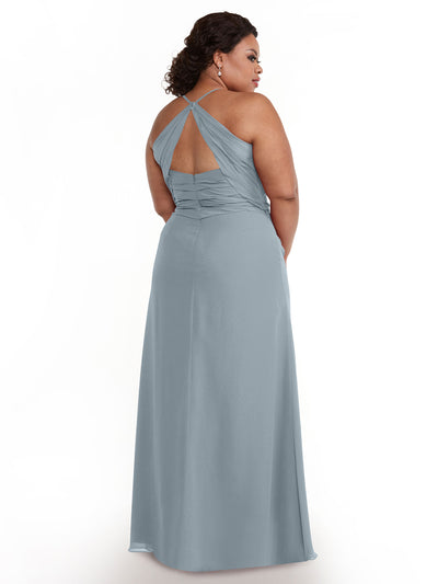A woman faces away, wearing Avery Austin's 80167—a floor-length light blue chiffon gown featuring a ruched crisscross halter back with a keyhole detail. Her loose curls complement the elegant dress against a plain white background.