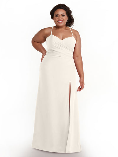 A woman smiles against a plain white background, wearing Avery Austin's 80167—a long chiffon bridesmaid dress featuring ruching, a sweetheart neckline, and a thigh-high slit.