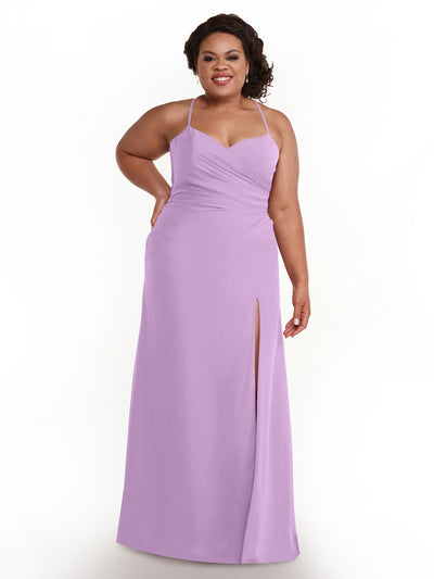 A woman stands smiling against a white background, wearing the Avery Austin 80167, a lilac chiffon dress with spaghetti straps, sleeveless design, and a thigh-high slit.