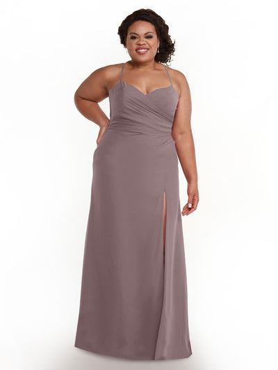 A woman in Avery Austin’s mauve chiffon dress (Style 80167) with spaghetti straps and a thigh-high slit smiles confidently with one hand on her hip against a plain white background.