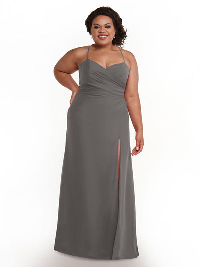A woman models the Avery Austin 80167, a sleeveless, floor-length steel gray dress with a thigh-high slit and sweetheart neckline, posing with a smile and one hand on her hip against a white background.