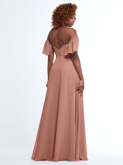 A woman with curly hair models Avery Austin’s floor-length mauve A-Line dress, style 80168, featuring chiffon fabric and off-the-shoulder ruffled sleeves. She stands with her back to the camera against a plain white background.