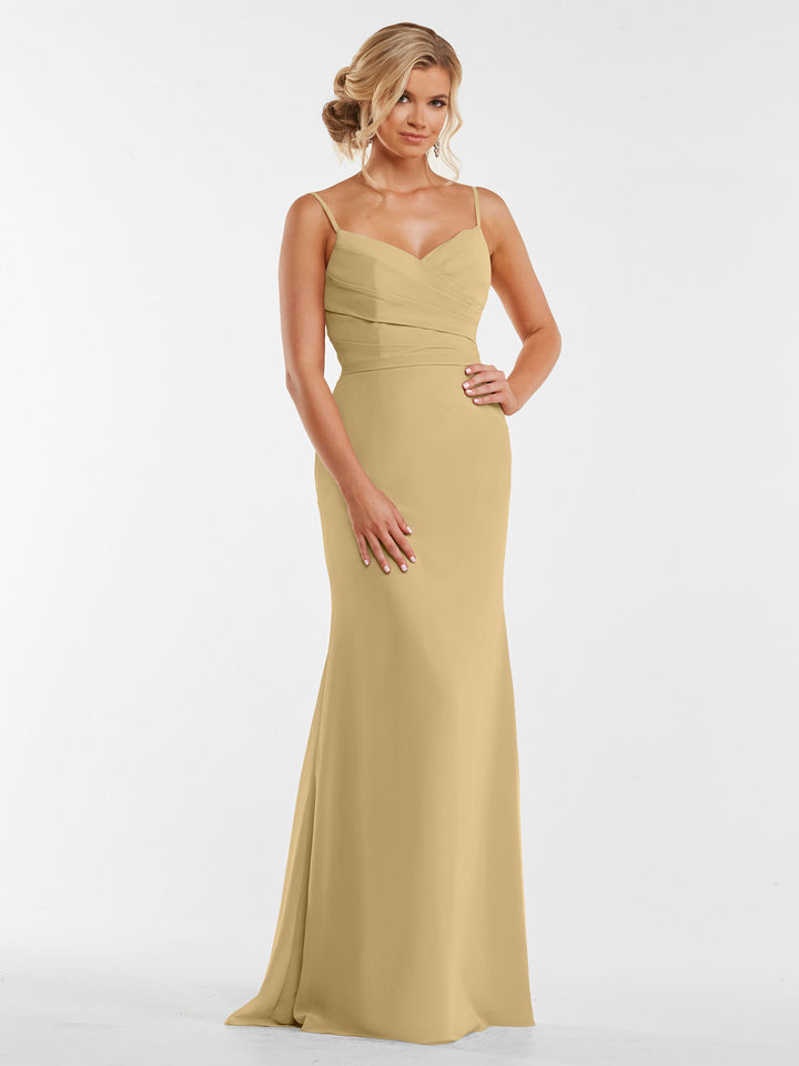 A woman models Avery Austin’s 80169—a sleeveless, floor-length champagne chiffon dress with thin straps and a fitted, pleated bodice—against a plain white background.