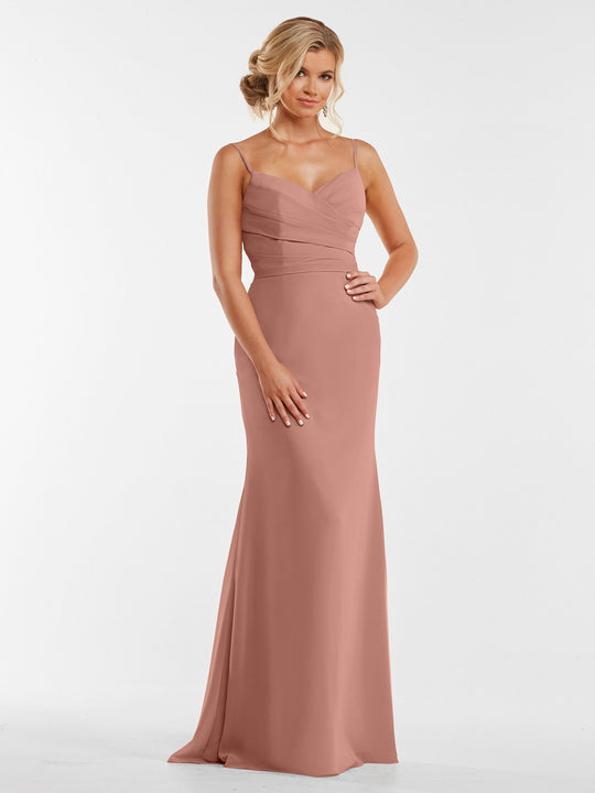 A woman wearing the Avery Austin TH-80169, a sleeveless blush pink chiffon dress with a fitted pleated bodice and thin straps, stands against a plain white background.