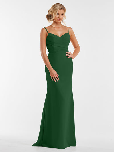A woman poses with one hand on her hip in Avery Austin style 80169, a sleeveless floor-length green chiffon dress with a pleated bodice. She stands against a plain white background, her blonde hair in an elegant updo.
