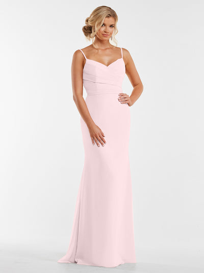 A woman models Avery Austin’s 80169: a long light pink chiffon dress with pleated bodice and thin straps, posing with an elegant updo and one hand on her hip against a plain white background.