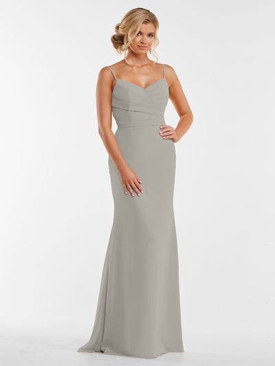 A woman models Avery Austin's 80169: a pale gray, floor-length chiffon dress with thin straps and a pleated bodice, standing against a white background with her hair in an elegant updo.