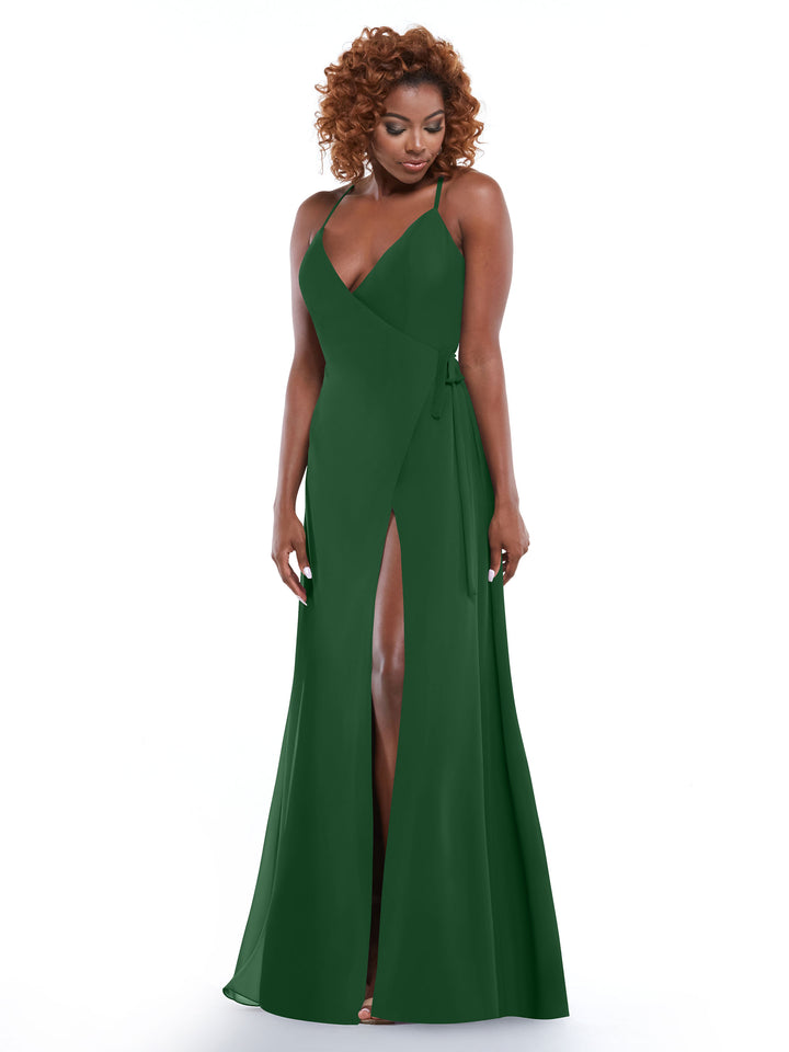 A woman models Avery Austin’s 80171: a sleeveless, deep green floor-length dress with spaghetti straps and double thigh-high slits, standing against a white background while smiling and looking down.
