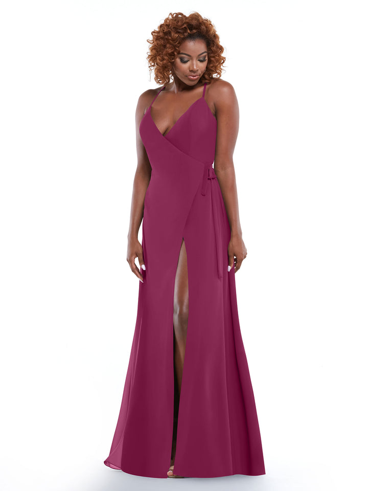 Model wears Avery Austin’s 80171, a sleeveless deep magenta sheath dress with a thigh-high slit. She stands against a plain white backdrop, her curly hair framing her face as she looks down with a gentle smile.