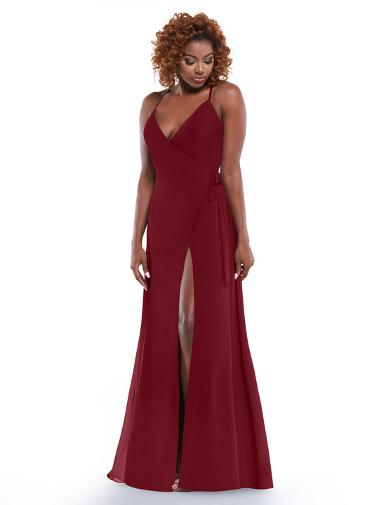 A woman with curly hair models Avery Austin’s 80171, a sleeveless deep red dress with thin straps and a high slit, set against a white background.