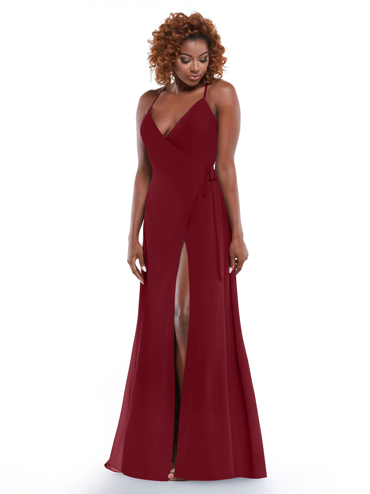 A woman with curly hair models Avery Austin’s 80171, a sleeveless deep red dress with thin straps and a high slit, set against a white background.