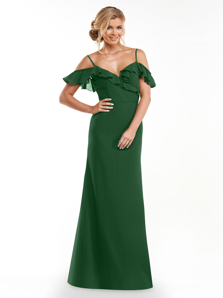 A woman in a floor-length, hunter green Avery Austin TH-80172 A-Line dress with a ruffled neckline and off-the-shoulder sleeves poses against a white background. She wears her blonde hair in soft waves and is smiling.