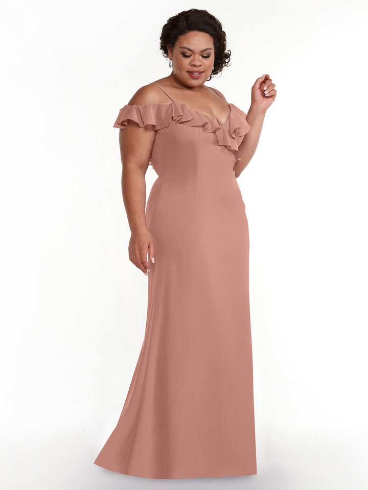 A woman wearing the Avery Austin 80172 floor-length A-line dress in dusty rose, featuring off-the-shoulder sleeves and ruffled neckline detailing, stands against a plain white background.