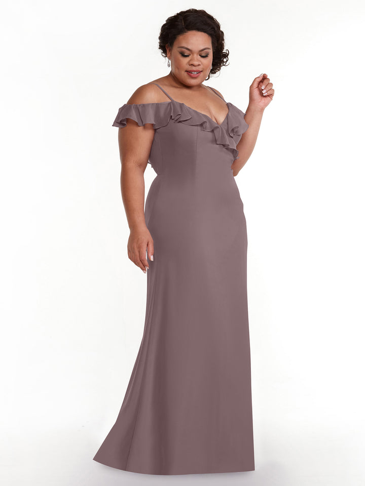 A woman models Avery Austin 80172, an off-the-shoulder mauve A-line dress with a ruffled neckline and floor-length skirt, standing against a plain white background.
