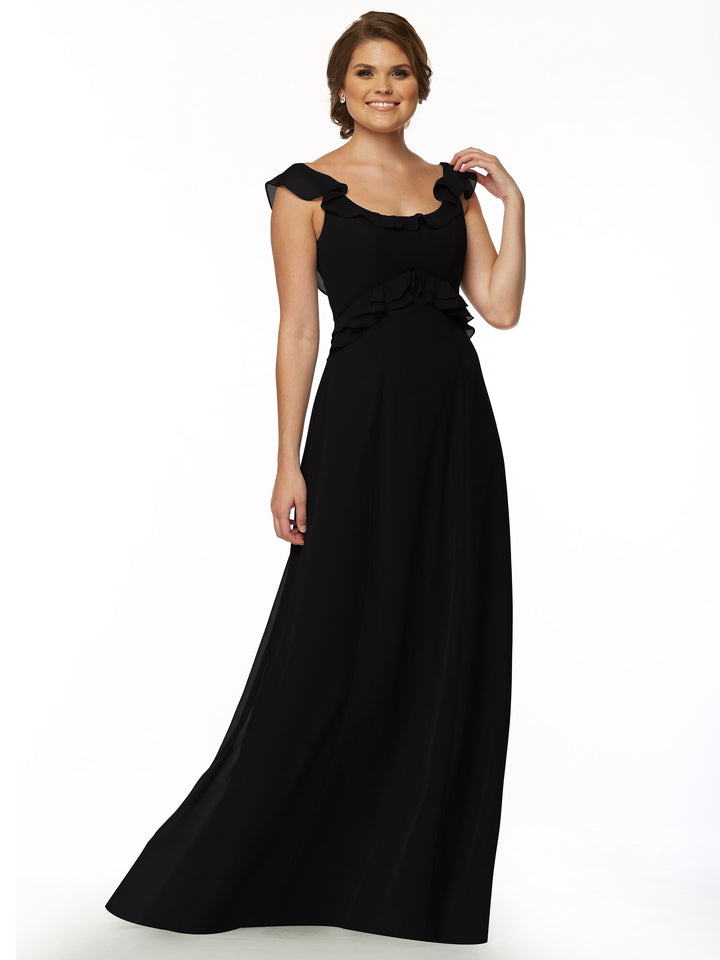 A woman with short brown hair smiles in Avery Austin’s floor-length black dress, style 80173, featuring a ruffled neckline, standing against a plain white background.