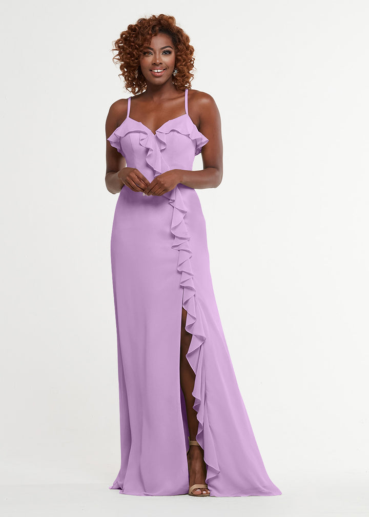 A woman wearing Avery Austin’s 80174—a lavender, floor-length A-line dress with ruffles, spaghetti straps, a sweetheart bodice, and a high slit—stands against a plain white background.