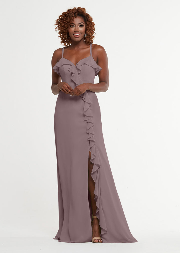 A woman smiles against a white background wearing the Avery Austin 80174, a mauve floor-length dress with thin straps, a sweetheart bodice, diagonal ruffle trim, and a thigh-high slit.