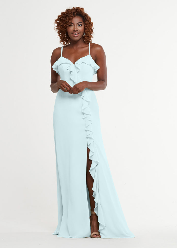 Wearing Avery Austin’s 80174, a woman poses in a sleeveless light blue A-line dress with ruffle details, a sweetheart bodice, and thigh-high slit against a plain white background.