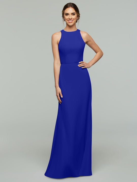 A woman smiles in the Avery Austin 80175, a sleeveless, floor-length cobalt A-line dress with a high neckline and keyhole back, posing with one hand on her hip against a plain gray background.