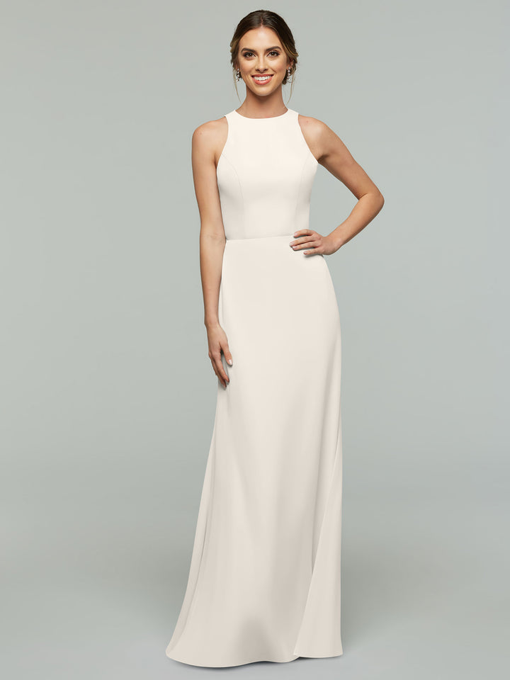 A woman models Avery Austin’s 80175, a sleeveless, floor-length ivory A-line dress with a high neckline, standing against a plain light gray background and smiling at the camera.