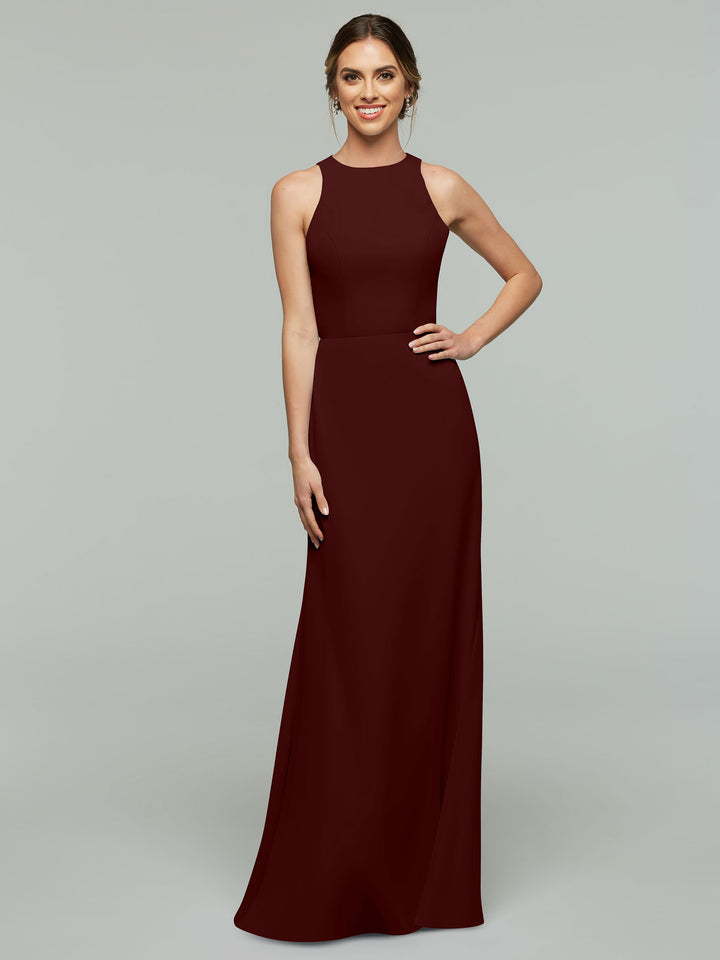 A woman smiles in the Avery Austin 80175—a sleeveless, floor-length A-line dress in Merlot with a high neckline. Her hair is styled back as she poses against a plain light gray background.