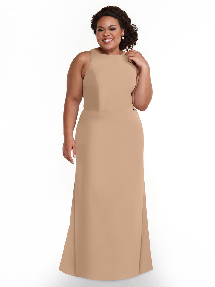 A woman with curly dark hair wears the Avery Austin 80175 sleeveless, floor-length A-line dress in buff. She stands smiling against a plain white background, touching her hair.