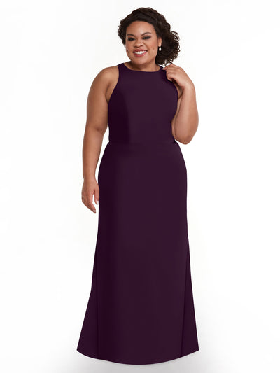 A woman touches her curly hair and smiles while wearing the Avery Austin 80175, a sleeveless floor-length dark purple A-line V-neck dress, standing against a plain white background.