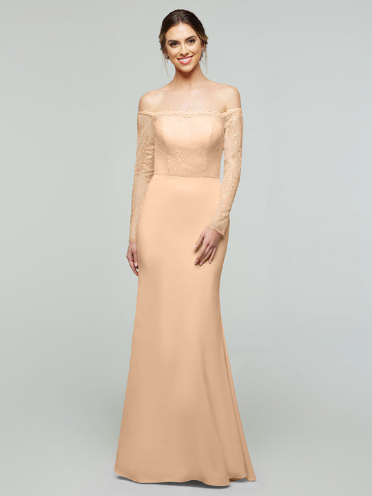 A woman stands smiling against a plain light gray background, wearing the averyaustin TH-80191—an elegant long peach Lux Chiffon mermaid dress with off-the-shoulder lace bodice and sleeves.