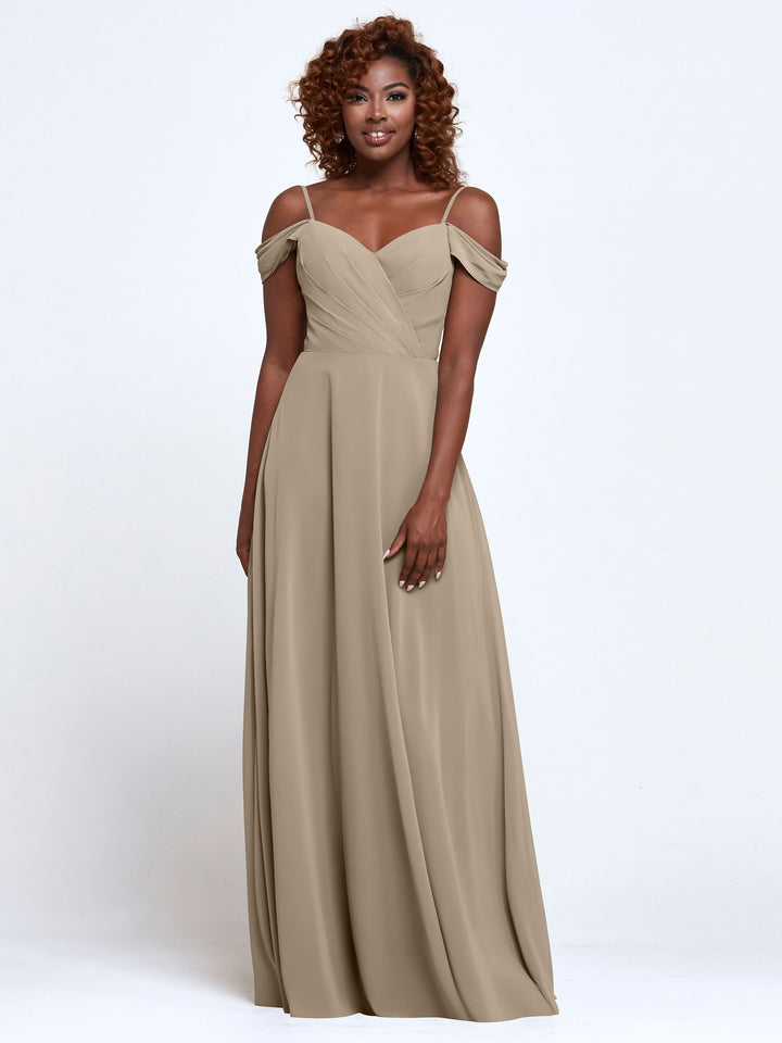 A woman with curly hair models Avery Austin’s TH-83003, a floor-length, latte chiffon bridesmaid dress featuring cold shoulder straps and a pleated bodice, standing against a plain white background.