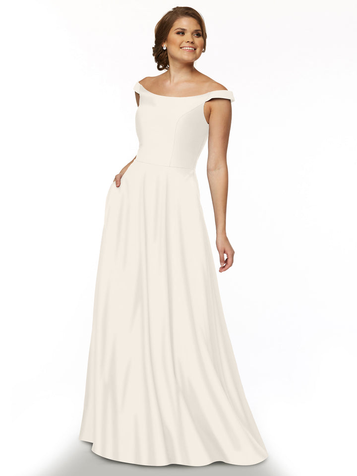 A woman smiles in the Avery Austin 83005, an ivory off-the-shoulder, floor-length gown with a fitted bodice, gently flared skirt, and convenient side pocket.