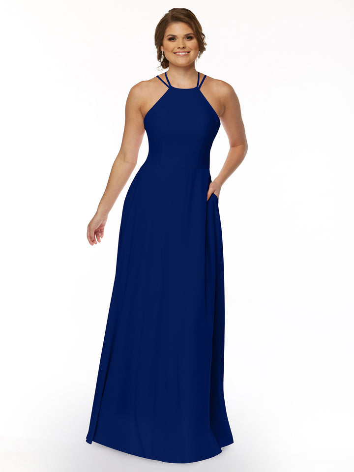 A woman smiles against a plain white background, wearing Avery Austin’s 83006—a floor-length, sleeveless royal blue A-line dress with a halter neckline.