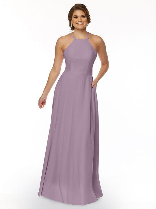 A woman smiles against a white background wearing the Avery Austin 83006: a sleeveless, floor-length lavender A-line dress with a halter neckline and side pockets.