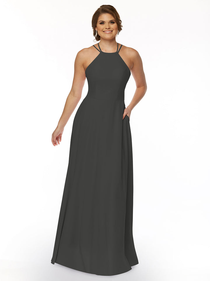 A woman smiles in the Avery Austin 83006, a sleeveless, floor-length dark gray A-line dress with a halter neckline and subtle pleats, against a white background.