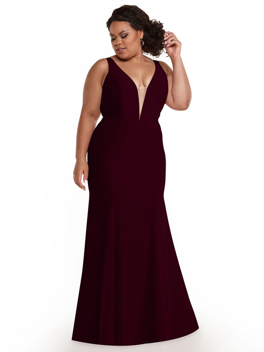 A woman in the Avery Austin TH-83010 maroon sleeveless floor-length gown with a plunging neckline stands against a white background, looking to the side and touching her hair.