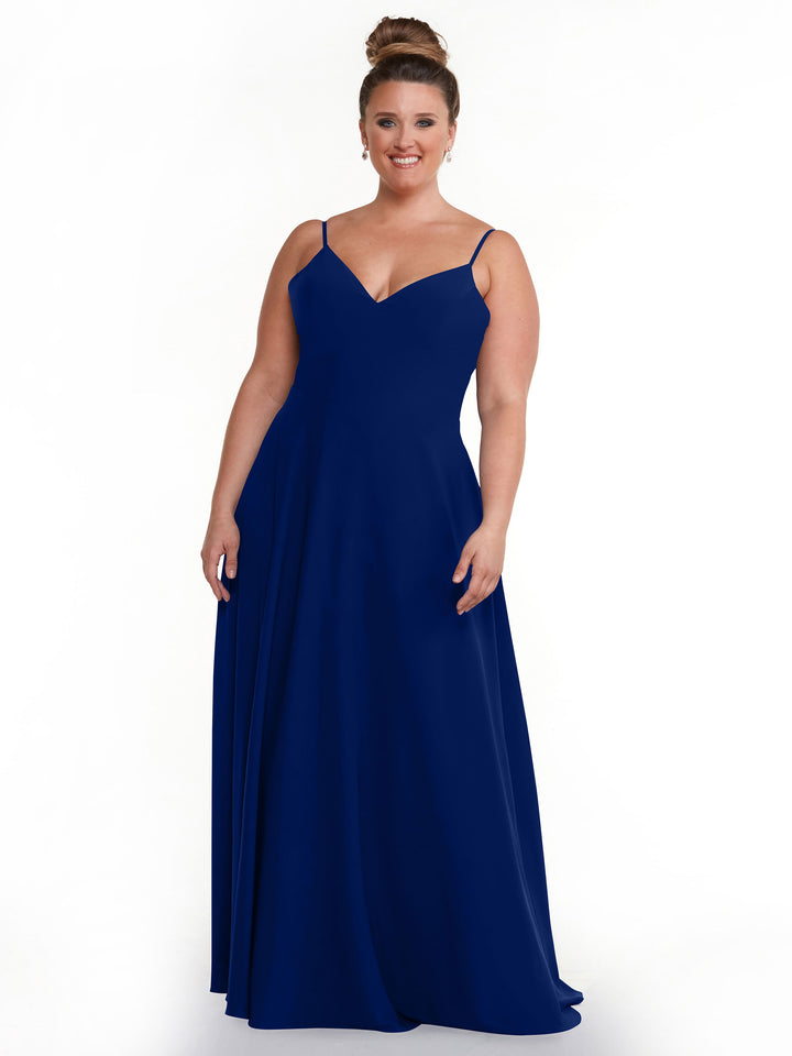 A woman smiles in the Avery Austin TH-83012, a royal blue, floor-length A-line dress with spaghetti straps and a V-neckline. Her hair is styled in a high bun as she poses against a plain white background.