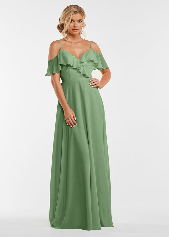 A woman models Avery Austin's 83013: a long sage green gown featuring off-the-shoulder sleeves and ruffled bodice details, set against a plain white backdrop.