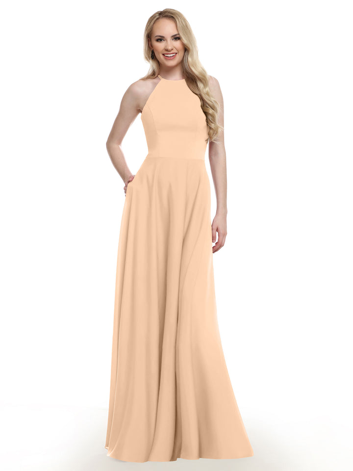 A woman with long blonde hair smiles against a plain white background, wearing Avery Austin style 83022: a sleeveless, floor-length peach A-line gown.