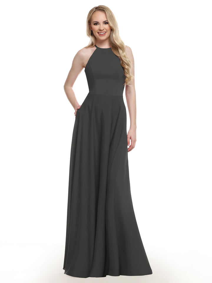 A woman with long blonde hair wears Avery Austin’s sleeveless, floor-length dark gray gown (style 83022) with an A-line skirt, smiling against a plain white background.