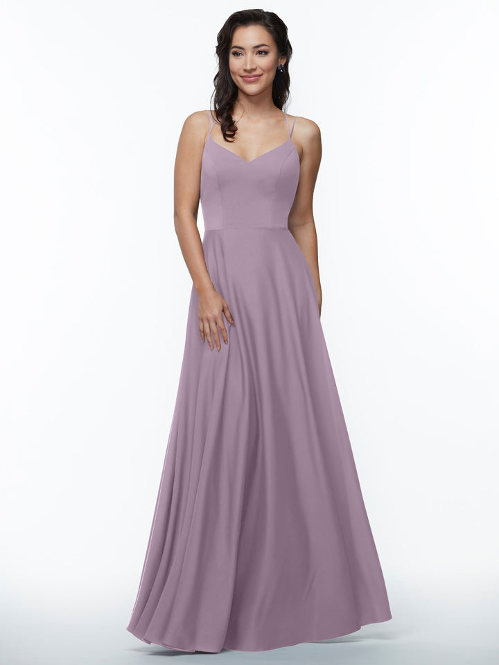 A woman smiles in an Avery Austin 83024 elegant long lavender A-line dress with double spaghetti straps and a flowing skirt, standing against a plain white background.