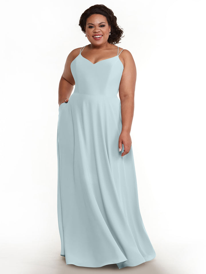 A woman with dark curly hair smiles, wearing Avery Austin&