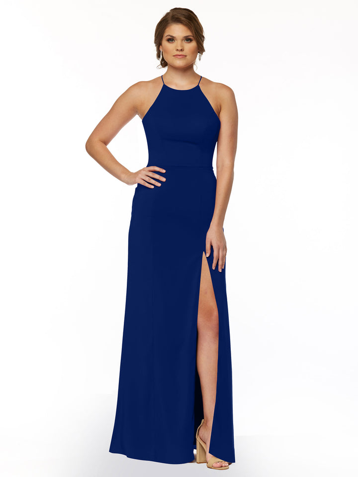 A woman poses with one hand on her hip against a white background, wearing Avery Austin style 83026—a royal blue, sleeveless sheath dress with a halter neck and thigh-high front slit.