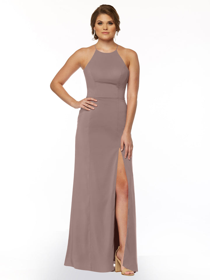 A woman poses with one hand on her hip in the Avery Austin 83026 mauve sheath dress, featuring a halter neckline and front slit, paired with heels against a plain white background.