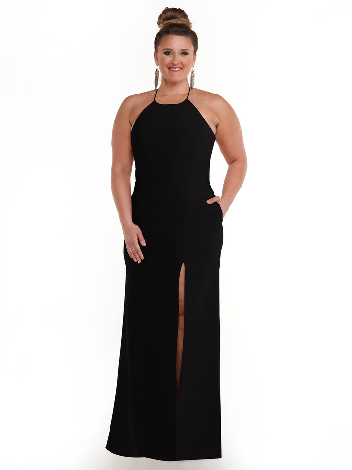 A woman wearing Avery Austin’s 83026—an elegant sleeveless black halter dress with a high slit—stands smiling against a white backdrop, her hair in a bun and accessorized with drop earrings.