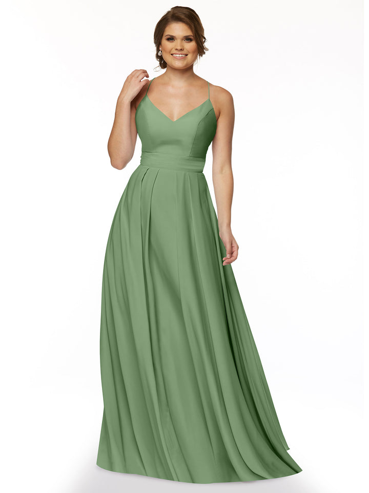 A woman wearing Avery Austin style 83027, a sleeveless sage green A-line dress with spaghetti straps and fitted waist, stands smiling against a plain white background.