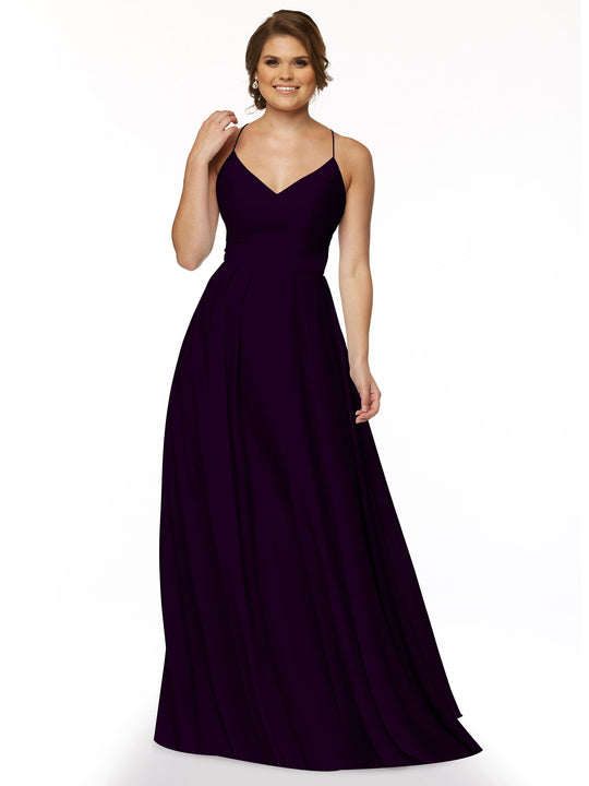 A woman with light brown hair up smiles against a white background, wearing Avery Austin’s 83027—a sleeveless, floor-length dark purple A-line dress with spaghetti straps—her hand resting near her shoulder.