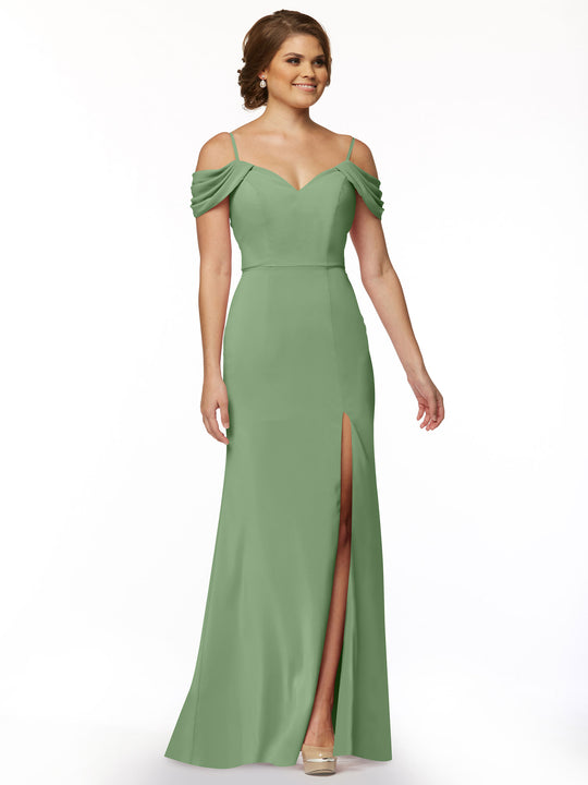 A woman models Avery Austin's 83029 dress—a light green, off-the-shoulder gown with draped sleeves, fitted bodice, and thigh-high slit. Her light brown hair is styled up as she poses against a plain white background.