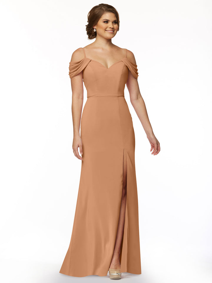 A woman models Avery Austin 83029, a floor-length off-the-shoulder dress with draped sleeves and front slit, against a white background.