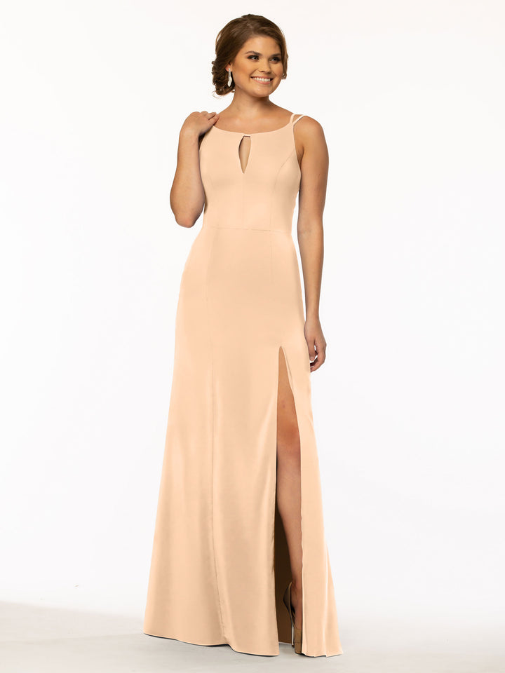 A woman models Avery Austin 83030, a sleeveless floor-length sheath dress with a keyhole neckline and high slit skirt in peach, smiling against a plain white background.