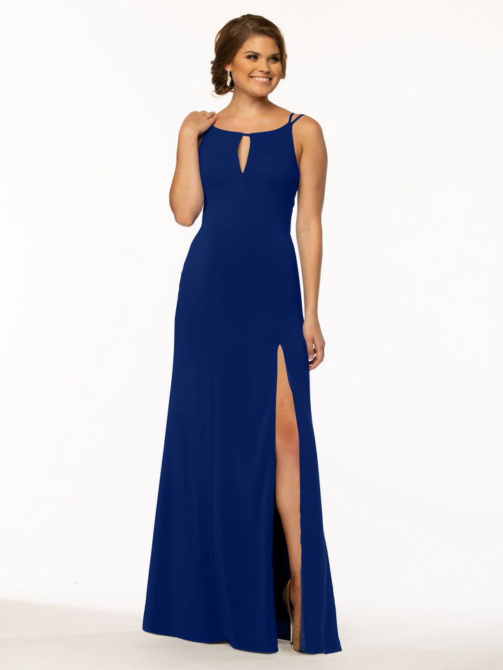 A woman in the Avery Austin TH-83030 cobalt sheath dress—sleeveless, floor-length with a bateau neck, front keyhole cutout, and high side slit—smiles while standing against a plain white background.