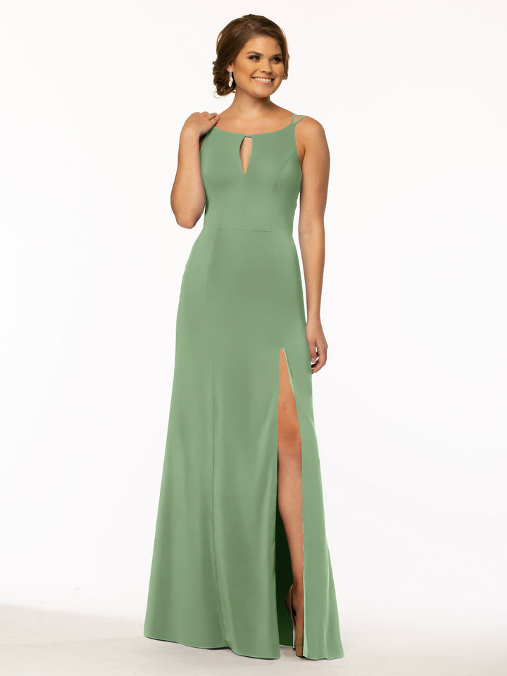 A woman in the Avery Austin 83030: a sleeveless, light green floor-length sheath dress with a front keyhole cutout and high-slit skirt, stands smiling against a plain white background.